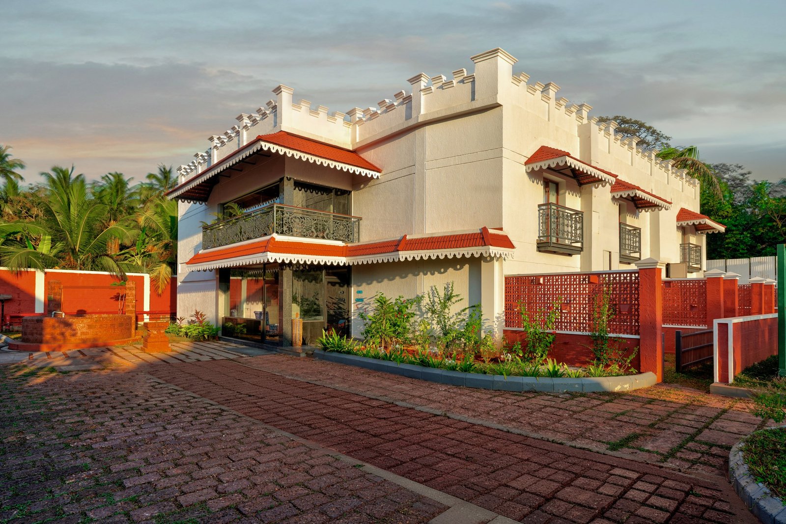 White villa with a red tiled roof and landscaped grounds